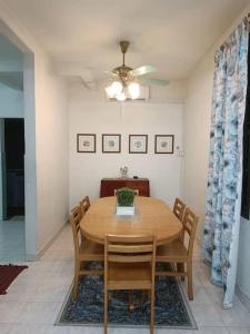 a dining room with a wooden table and chairs at Cozy house with free parking near Utm, Legoland in Skudai