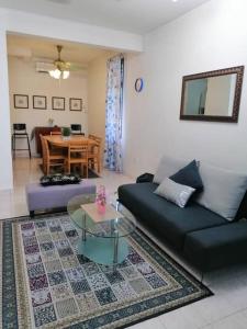 uma sala de estar com um sofá e uma mesa em Cozy house with free wifi and parking near Utm, Legoland em Skudai