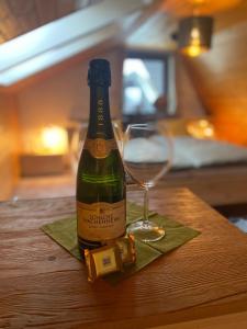 a bottle of wine and a glass on a table at Traum-Maisonette auf 1.000m mit Pool und Sauna in Schönwald