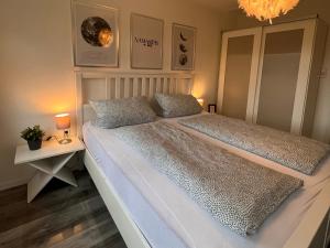 a bedroom with two beds and a chandelier at Unterwegs an der Nordsee in Wilhelmshaven