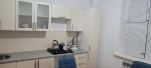 アティラウにあるКвартираの小さなキッチン(白いキャビネット、カウンタートップ付)