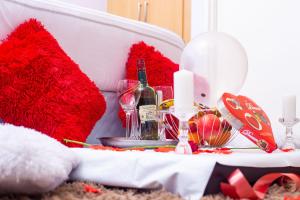 una mesa decorada en rojo y una botella de vino en WhiteHouse Lodge en Harare