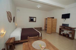 een slaapkamer met een bed en een tafel en een televisie bij Casa Amaiur in Huichapan