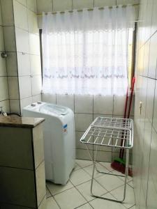 cocina con lavadora y ventana en Hermoso departamento en Bombas con vista al mar en Bombinhas