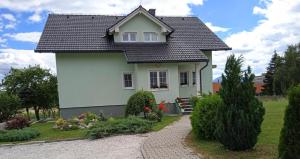 a white house with a black roof at Apartman M. Rados in Kupres