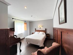 Un dormitorio con una cama, un sofá y una silla. en Hotel Comillas, en Comillas