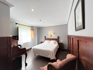 מיטה או מיטות בחדר ב-Hotel Comillas
