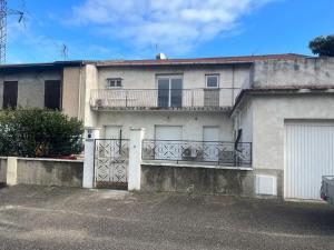 a white house with a balcony and a garage at CHOPIN’studio BALNEO’2pers in Chasse-sur-Rhône