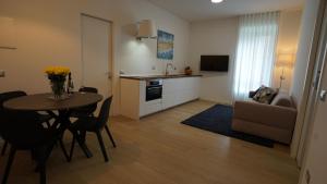 uma cozinha e sala de estar com uma mesa e um sofá em Danae Home em Milão