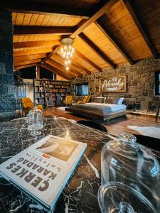 a room with a bed and a table with a book at Çathan Art Hotel in Ayder Yaylasi