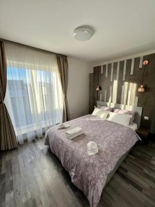 sypialnia z dużym łóżkiem z dwoma ręcznikami w obiekcie MONCLER RESIDENCE w Braszowie