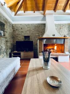 a living room with a fireplace and a table at Citrus garden in Ancient Epidauros