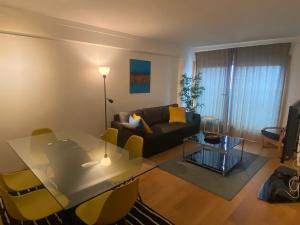 a living room with a couch and a table and chairs at Suites Panoramic - River View in Lisbon