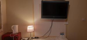 una televisione appesa all'angolo di una stanza di Delightful home stay - Double ensuiteroom. a Glasgow