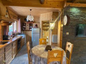 cocina con mesa y nevera en Chalet d' Annelise, en Gérardmer