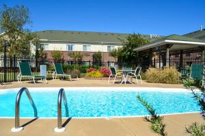 a swimming pool with chairs and a table next to a building at InTown Suites Extended Stay Decatur AL in Decatur