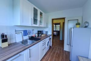 a kitchen with white cabinets and a sink and a refrigerator at Comfortable 3 Room apartment, ideal for Messe fair in Hannover