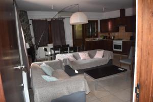 a living room with two couches and a kitchen at Moutoullas Apartment in Nicosia