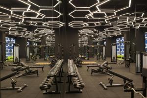 a gym with rows of exercise equipment and lights at Maxx Royal Kemer Resort in Kemer