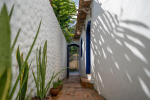 a hallway of a house with plants and a door at Arandu Casa Hotel Quadrado in Trancoso