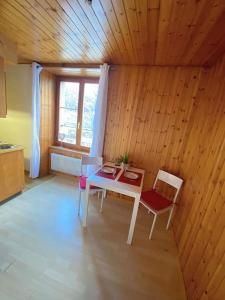 Habitación con mesa, 2 sillas y ventana en Studio cosy au centre du village, en Evolène