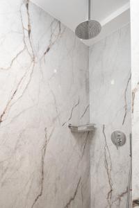 a bathroom with marble walls and a shower at Evans Luxurious Apartment 2 in Heraklio