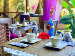 a table with two coffee cups on top of it at Pousada CasAlice in Jericoacoara