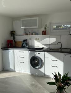 eine weiße Küche mit Waschmaschine in der Unterkunft CASALINO DI ANNA in Wensickendorf