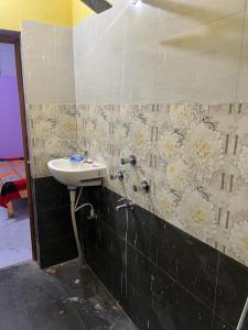 a bathroom with a sink and flowers on the wall at Riru girlstay in Patna