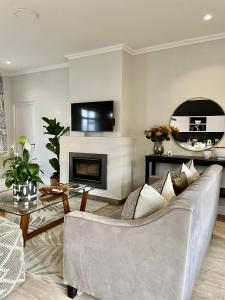 a living room with a couch and a fireplace at The Village Cottage in Franschhoek
