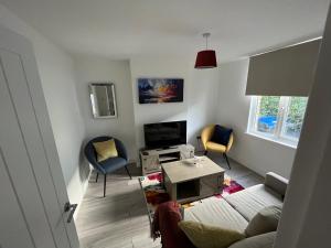 un soggiorno con divano e 2 sedie di 3 Bed 2 Lounge House up to 40pc off Monthly in Addlestone by Angel and Ken Serviced Accommodation Great Value for Long-term Stay a Addlestone