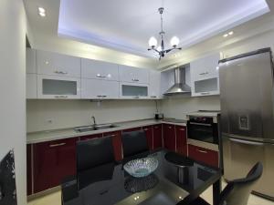 kuchnia z białymi szafkami i czarnym stołem w obiekcie Tirana New Bazaar - Apartment no•2 w Tiranie