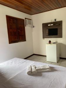 1 dormitorio con 1 cama con 2 toallas en Pousada Sol & Mar, en Itacaré