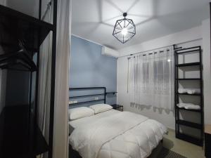 sypialnia z białym łóżkiem i żyrandolem w obiekcie Tirana New Bazaar - Apartment no•2 w Tiranie