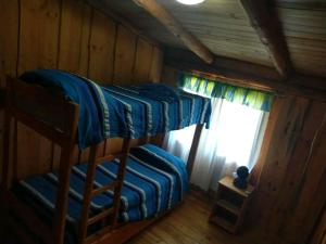 two bunk beds in a cabin with a window at Murmullos del bosque in Lago Puelo