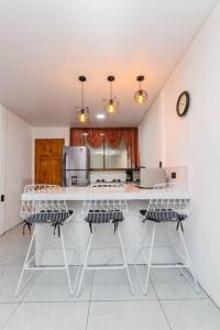 cocina con encimera blanca y algunas sillas en Casa Hoja Monteverde 2, en Monteverde