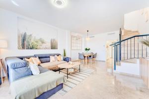 salon z niebieską kanapą i stołem w obiekcie Black Beach Luxury Vacation House w mieście Puerto de Santiago +37 zdjęć