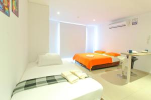 1 dormitorio con 2 camas y mesa. en Apartamentos Velas al Mar Rodadero en Puerto de Gaira