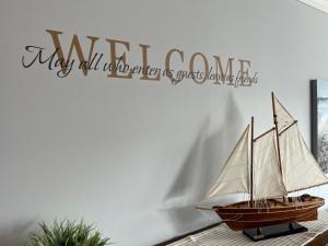 a wooden boat with a welcome sign on a wall at Sandpiper SC Luxe Oceanview Condo in Private Paradise in Oceanmarsh Subdivision