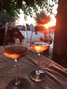 dos copas de vino sentadas en una mesa con la puesta de sol en Farmhouse Cubani en Bale