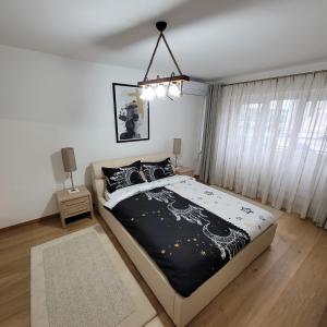 een slaapkamer met een groot bed en een kroonluchter bij Apartament Lux - Dorobantilor in Cluj-Napoca