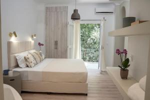 a white bedroom with a large bed and a window at Romantic apartment with hot tub next to Acropolis in Athens
