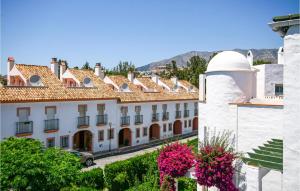 a row of buildings in a town with flowers at Amazing Apartment In Mijas Costa With House A Mountain View in Mijas Costa