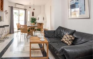 a living room with a black leather couch and a table at Amazing Apartment In Mijas Costa With House A Mountain View in Mijas Costa