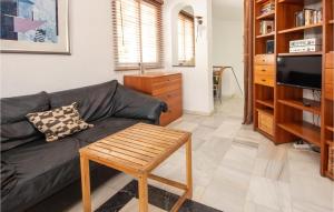 a living room with a black couch and a table at Amazing Apartment In Mijas Costa With House A Mountain View in Mijas Costa