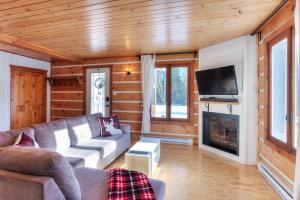 ein Wohnzimmer mit Couch und Kamin in der Unterkunft Hjort cottage - 4 Bedrooms 9 people 2 bathrooms in La Macaza