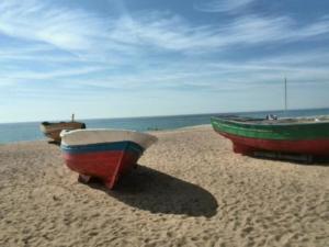deux bateaux assis sur une plage près de l'eau dans l'établissement Barcelona Badalona Playa Terraza, à Badalona