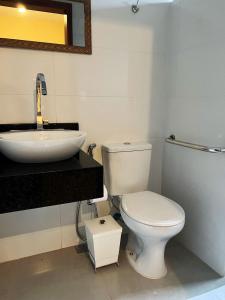 a bathroom with a white toilet and a sink at Pousada La Belle de Jour in Chapada dos Guimarães