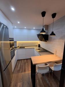 Una cocina con una mesa de madera y un refrigerador. en Apartamento la moraña, en Arévalo