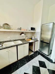a kitchen with two sinks and a refrigerator at V.60 in Nueve de Julio